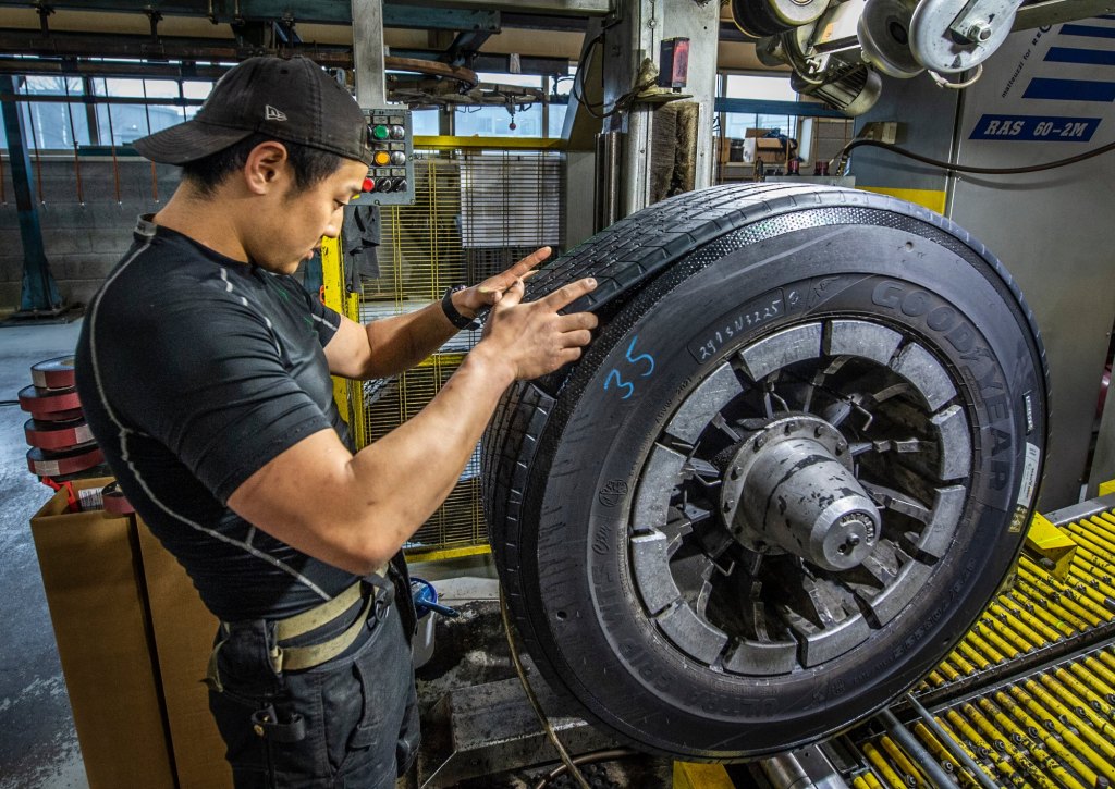 Bilde av Tobias som legger løpende slitebane på et lastebildekk.